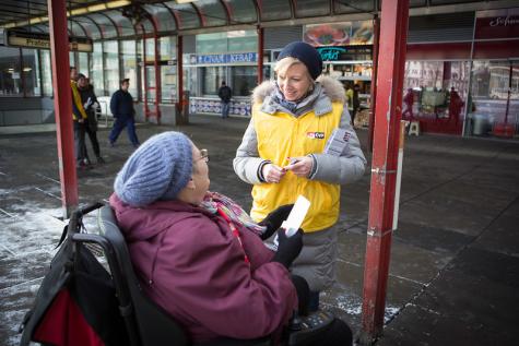 Eine Frau verteilt &Ouml;VP-Material an eine Frau im Rollstuhl