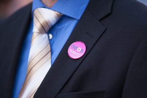 Ein Mann trägt einen NEOS Anstecker an seiner Jacke