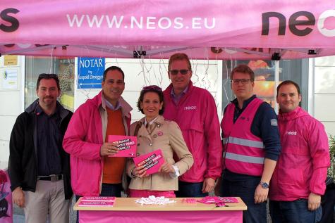Ein Wahlkampfstand der NEOS mit mehreren Personen 