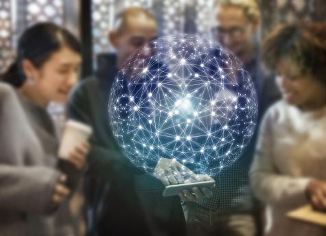 Menschen schauen auf ein Handy, im Vordergrund Erde vernetzt