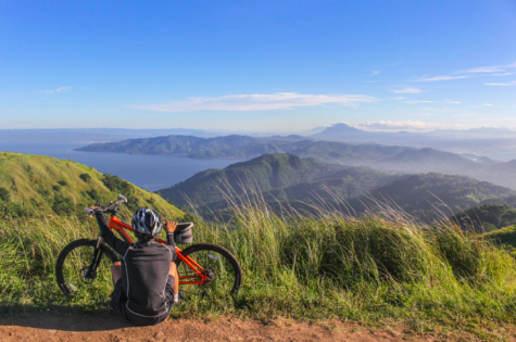 Mann in der Natur neben seinem Fahrrad