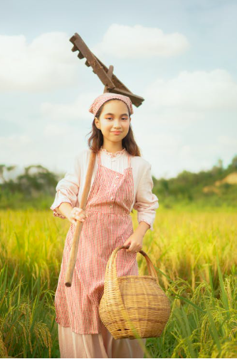 M&auml;dchen mit Rechen auf dem Feld