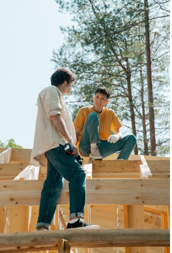 Zwei Jugendliche bauen mit Holz