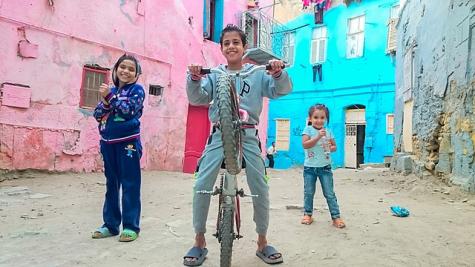 Drei Kinder vor einer H&auml;userfront