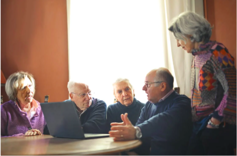 Mehrere Senioren um ein Laptop