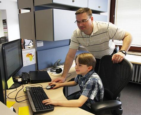 Ein Lehrer &uuml;bersieht einen Jungen, der am PC arbeitet