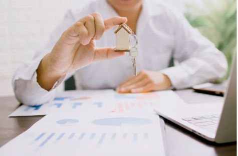 Mann h&auml;lt Schl&uuml;ssel mit Hausanh&auml;nger