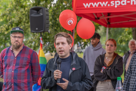 Kevin K&uuml;hnert spricht an einem SPD-Stand am Tag der Deutschen Einheit in M&ouml;dlareuth 2023