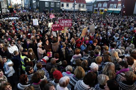 Gro&szlig;e Menschenmenge auf einem Platz, viele tragen traditionelle Kleidung und halten Schilder. Stimmung ist demonstrativ und engagiert.