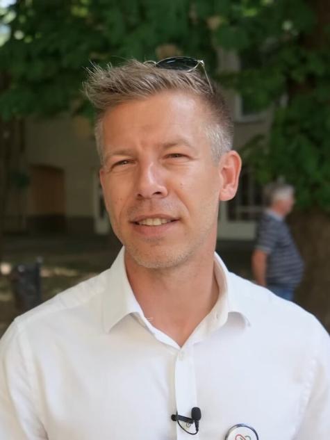 Der ungarische Politiker P&eacute;ter Magyar wird von G&aacute;bor R&eacute;v&eacute;sz interviewt, nachdem er am 20. Mai 2024 im Vorfeld der Europawahlen in Ungarn bei einer Wahlkampfveranstaltung in Csongr&aacute;d eine Rede gehalten hat. - Mann mit kurzem, blonden Haar und einem wei&szlig;en Hemd, steht im Freien vor einem unscharfen Hintergrund.