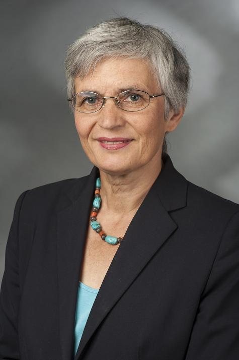 Ute Finckh-Kr&auml;mer ist eine deutsche Politikerin (SPD) und Pazifistin. - Portr&auml;t einer Frau mit kurzen grauen Haaren, Brille und einem dunkelblauen Blazer, l&auml;chelnd vor einem grauen Hintergrund.