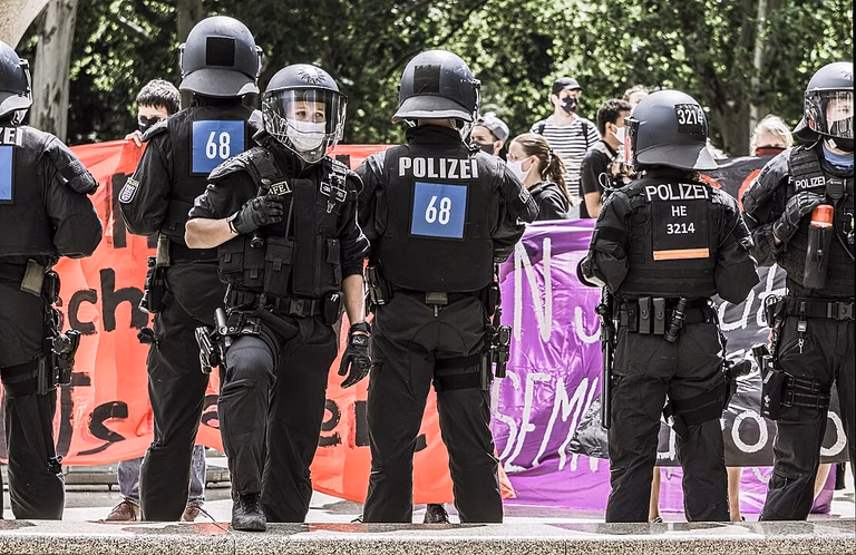 Eine Gruppe Polizisten vor einem Demozug