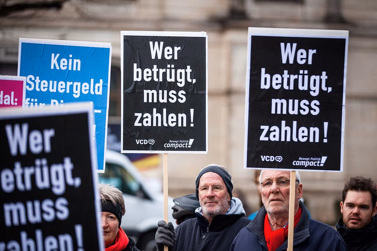 Demo gegen unfaire Besteuerung mit mehreren Schildern