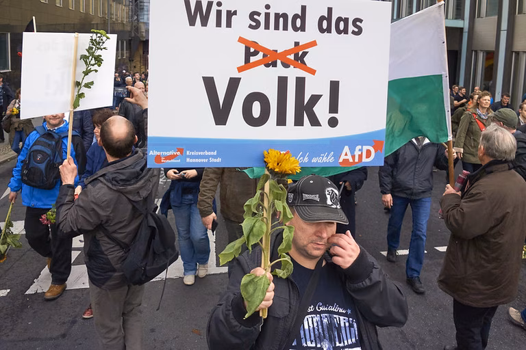 AFD-Demonstration, Berlin Mitte, Reinhardtstra&szlig;e. Text auf dem Schild: &bdquo;Wir sind das Volk&ldquo; (das Wort &bdquo;Pack&ldquo; wurde durchgestrichen).
