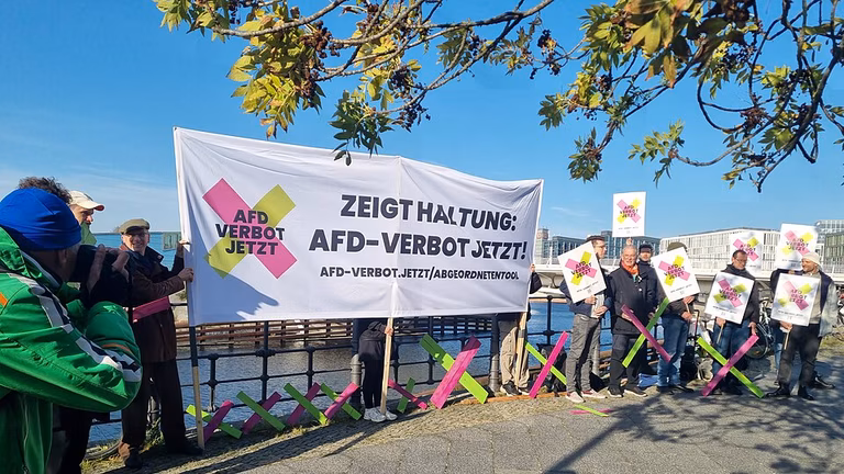 Kundgebung der Initiative #AfDverbotJetzt zur Fordergung nach einem Pr&uuml;fauftrag zum Verbot der AfD durch den Bundestag vor dem Geb&auml;ude der Bundespressekonferenz in Anwesenheit von Fotografen, einer Reporterin des Deutschlandfunks und eines Fernsehteams des RBB.